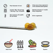 Cargar imagen en el visor de la galería, Perlas de salsa de soja doradas y marrones sobre una cuchara metálica.