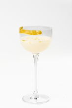Cargar imagen en el visor de la galería, Copa de cóctel con bebida clara y borde decorado con pasta de oliva verde.