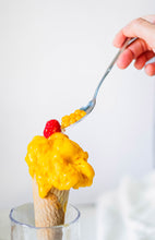 Cargar imagen en el visor de la galería, Perlas de mango Caviaroli en cuchara sobre helado de mango en cono con frambuesa.