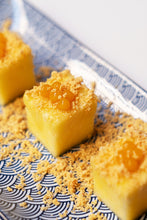 Cargar imagen en el visor de la galería, Cubos de mango con perlas de mango y migas crujientes sobre plato azul y blanco.