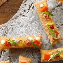 Cargar imagen en el visor de la galería, Rollitos crujientes con caviaroli, jamón, queso y rúcula sobre piedra.